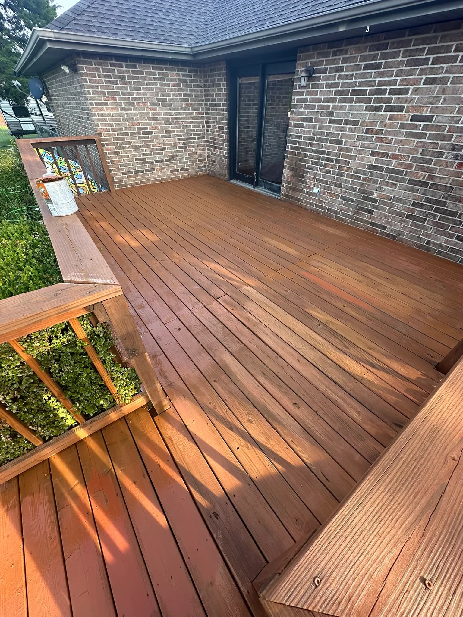 New stained wood deck walkway built along a brick house