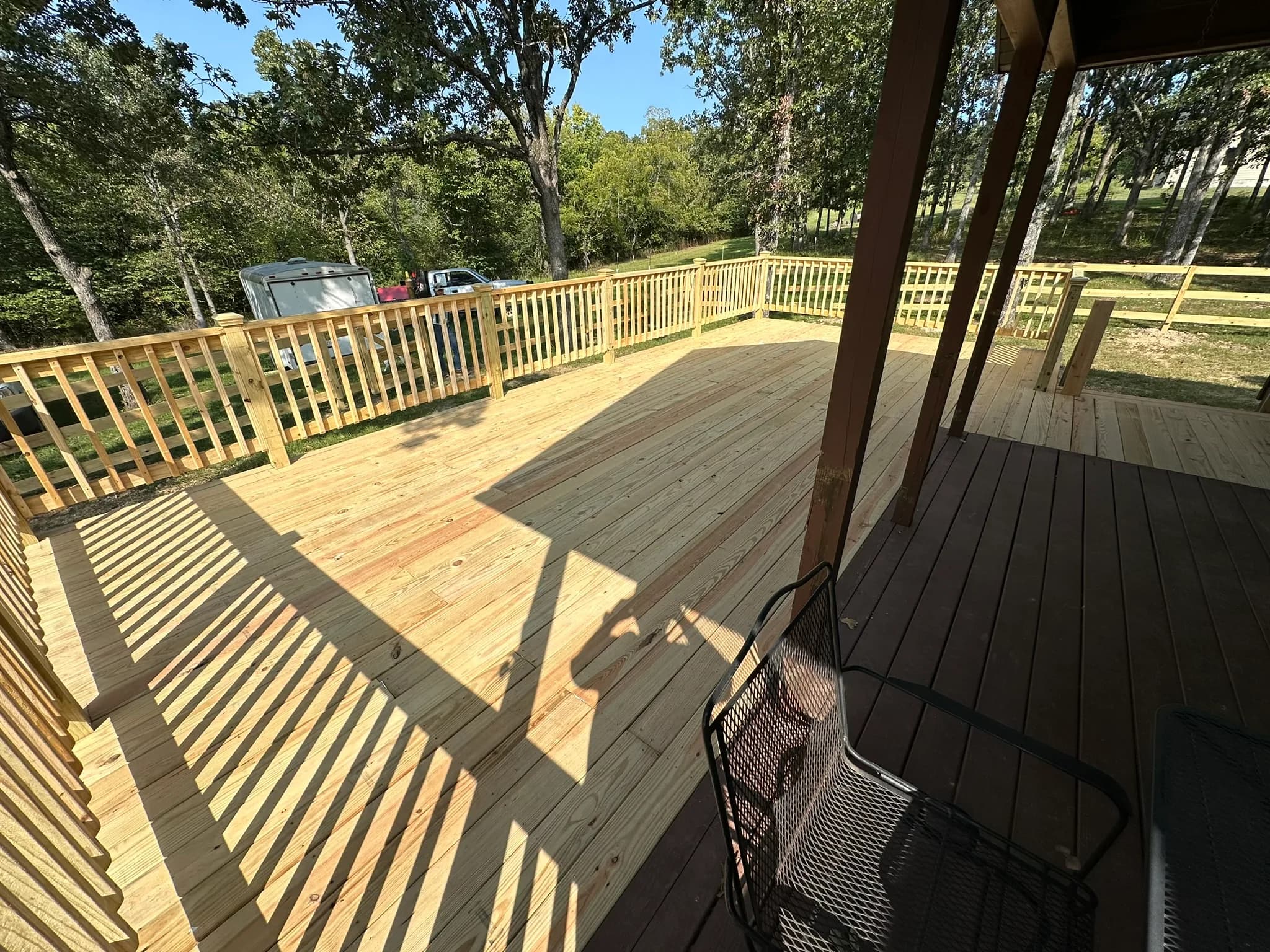 Sunlit backyard deck with pressure-treated railing and seating area