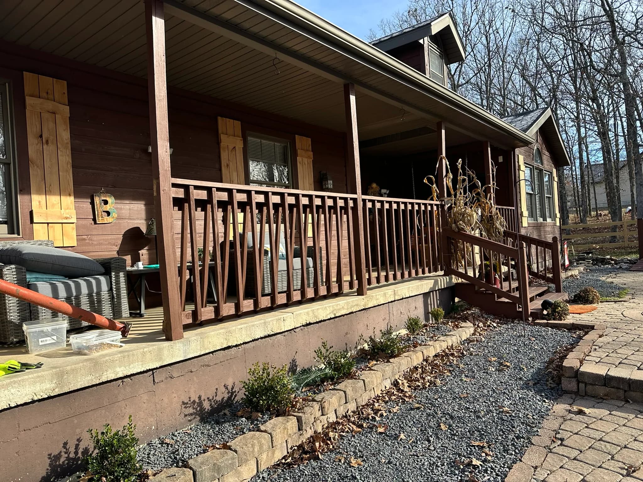 Covered front porch deck with wood railing at a country home