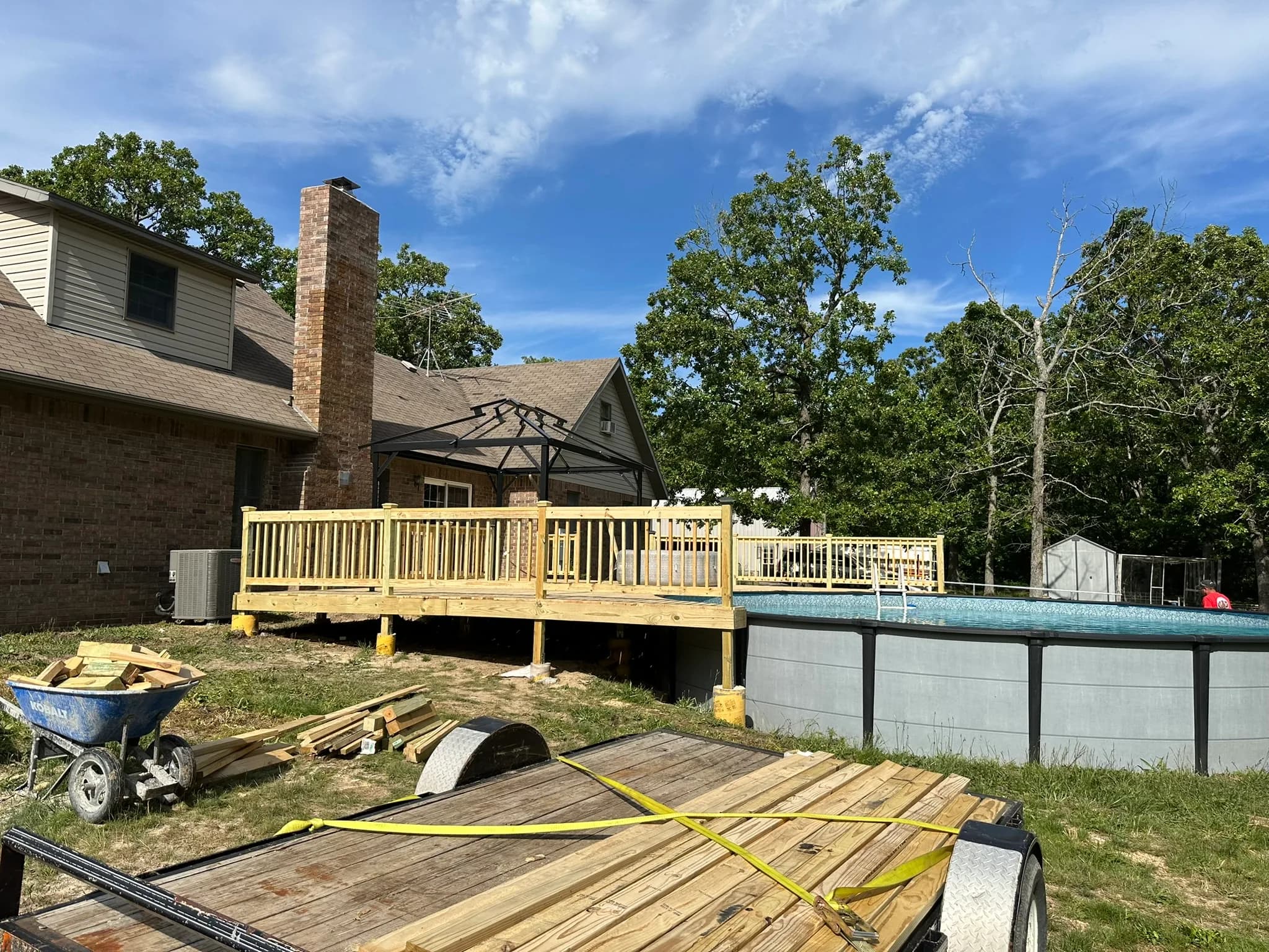 New poolside deck addition with wood railing and outdoor steps