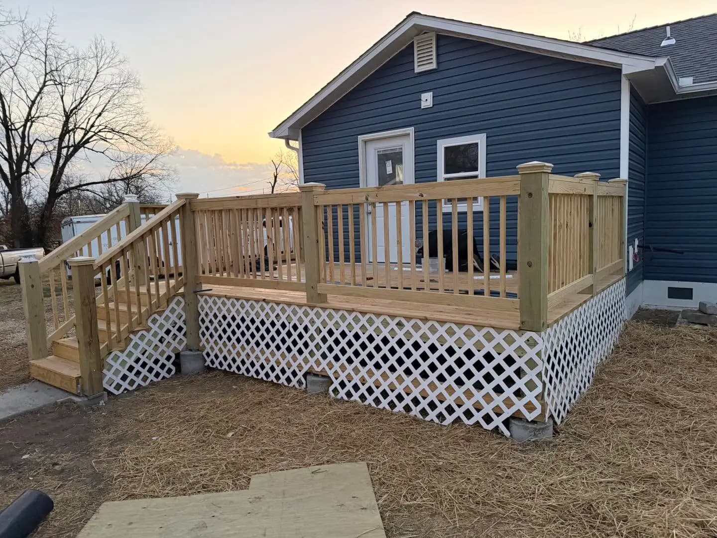 Finished backyard deck with wood railing and lattice skirting