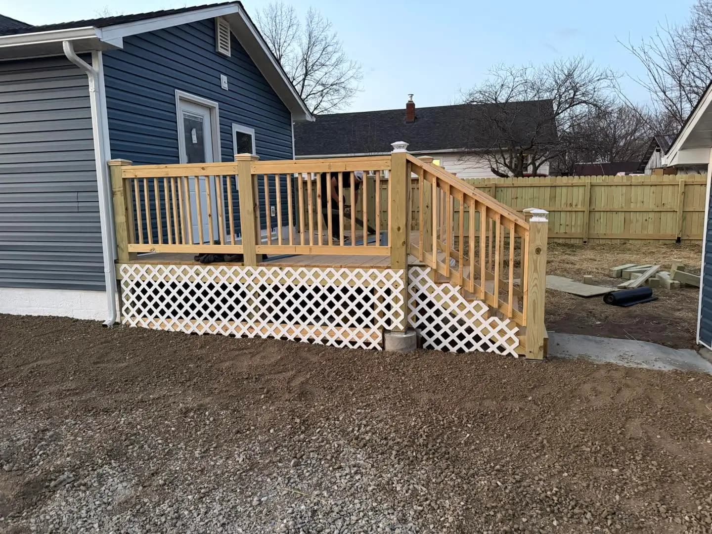 Completed pressure-treated deck with stairs and white lattice