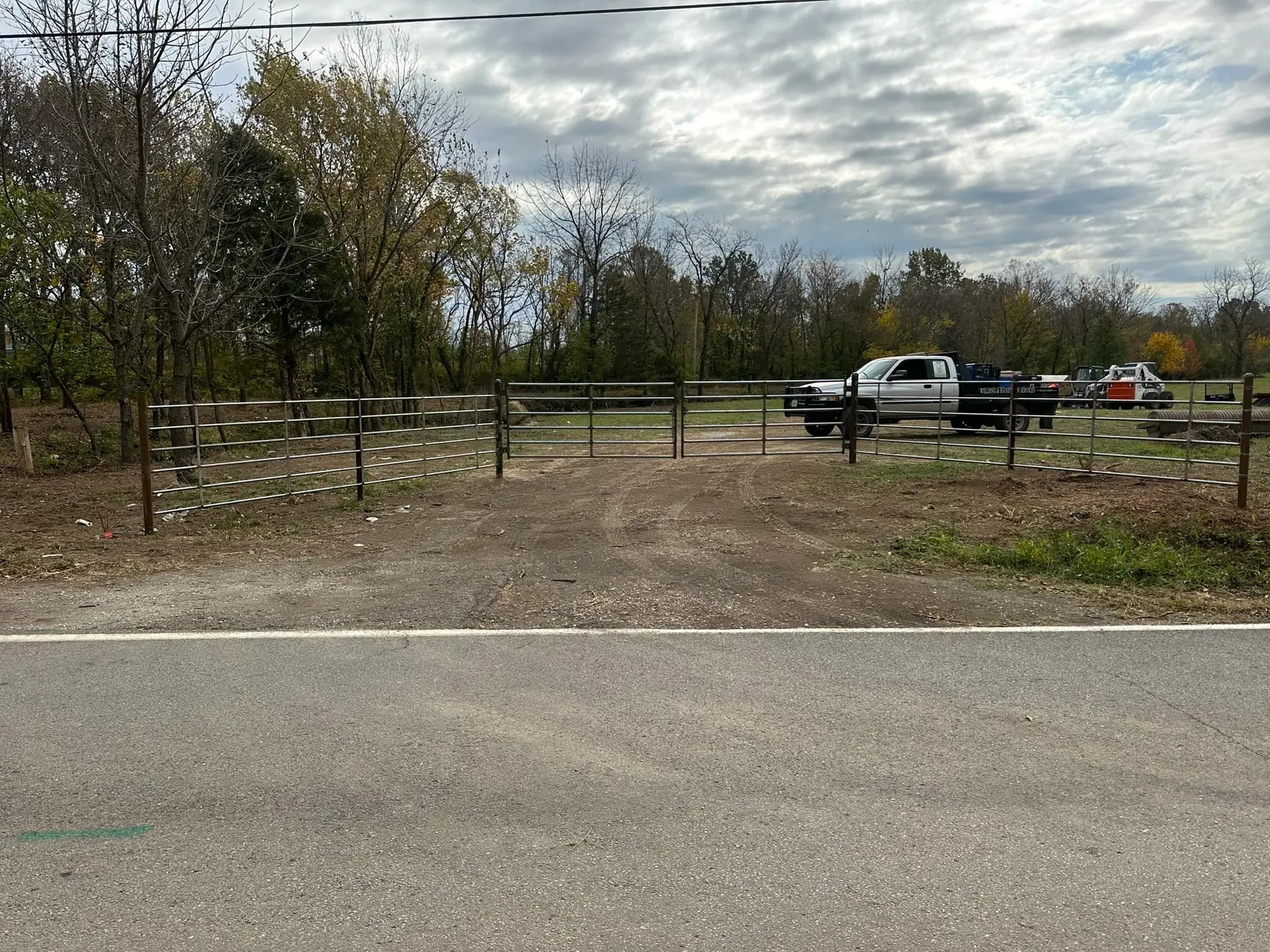 Pipe corral fence and gate beside a rural road