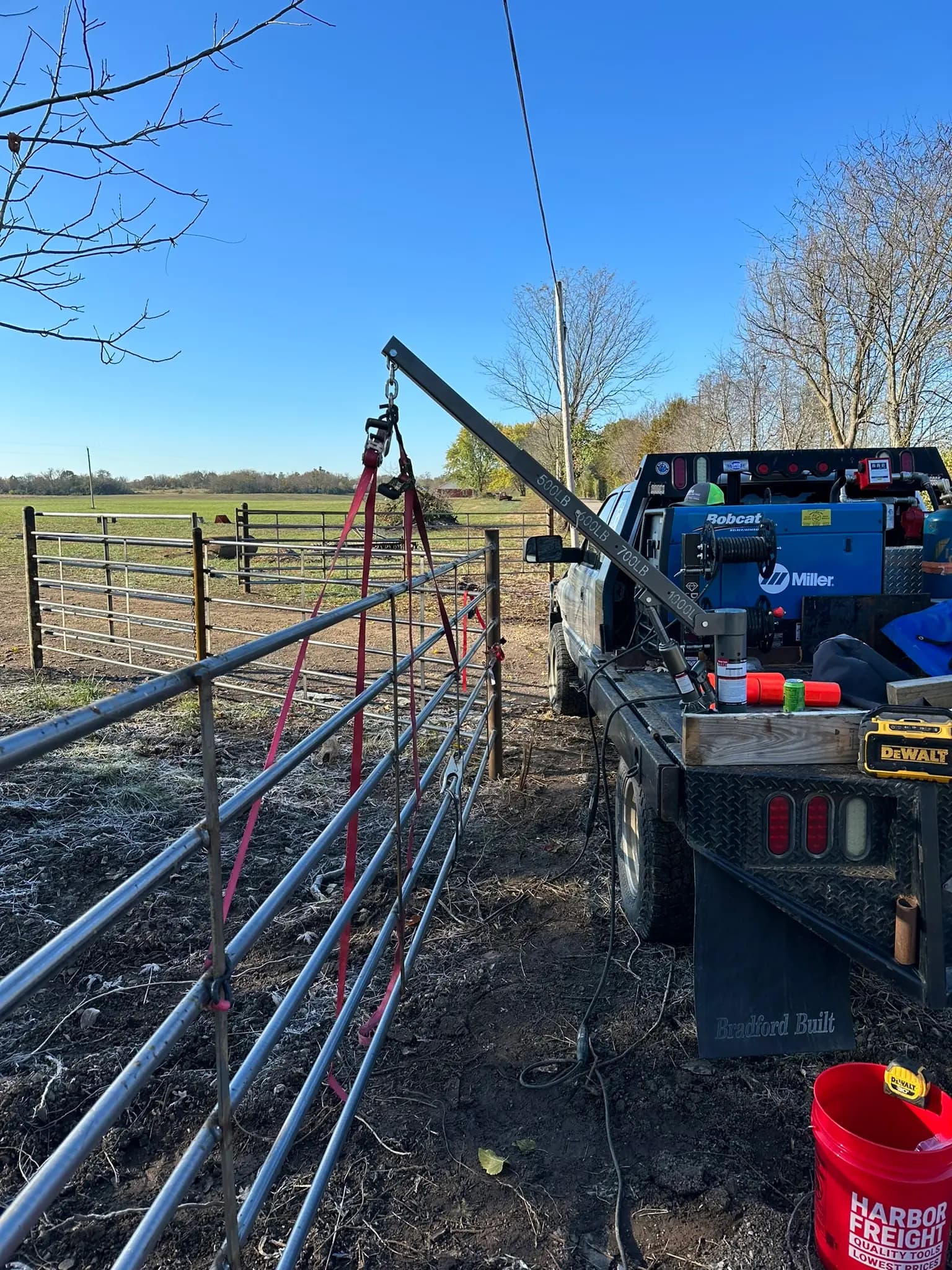 Mobile welding rig beside a pipe fence gate installation