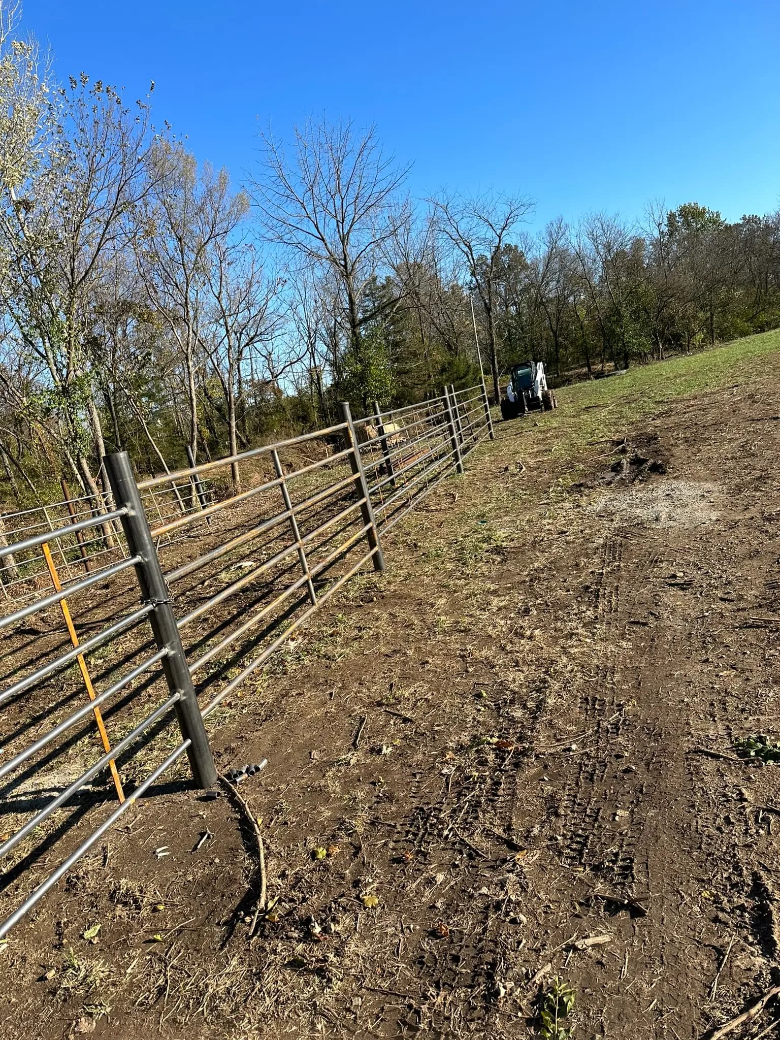 Continuous fence line following a sloped pasture edge