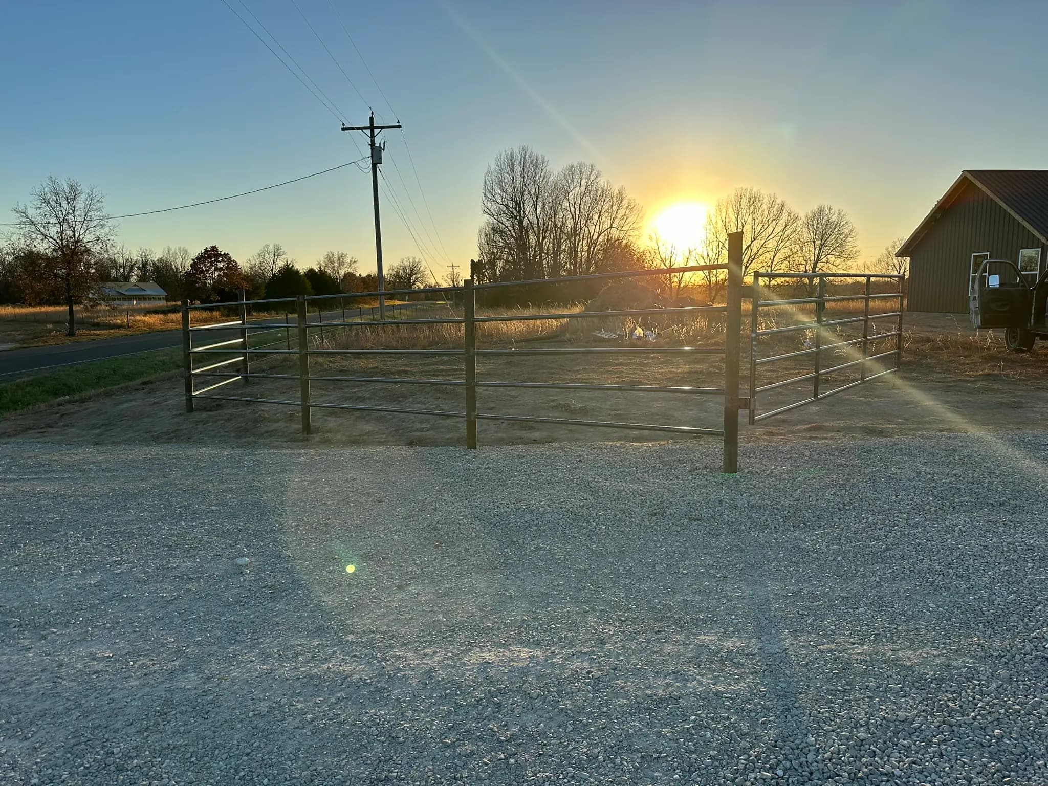 Pipe driveway gate at sunset on a gravel entrance