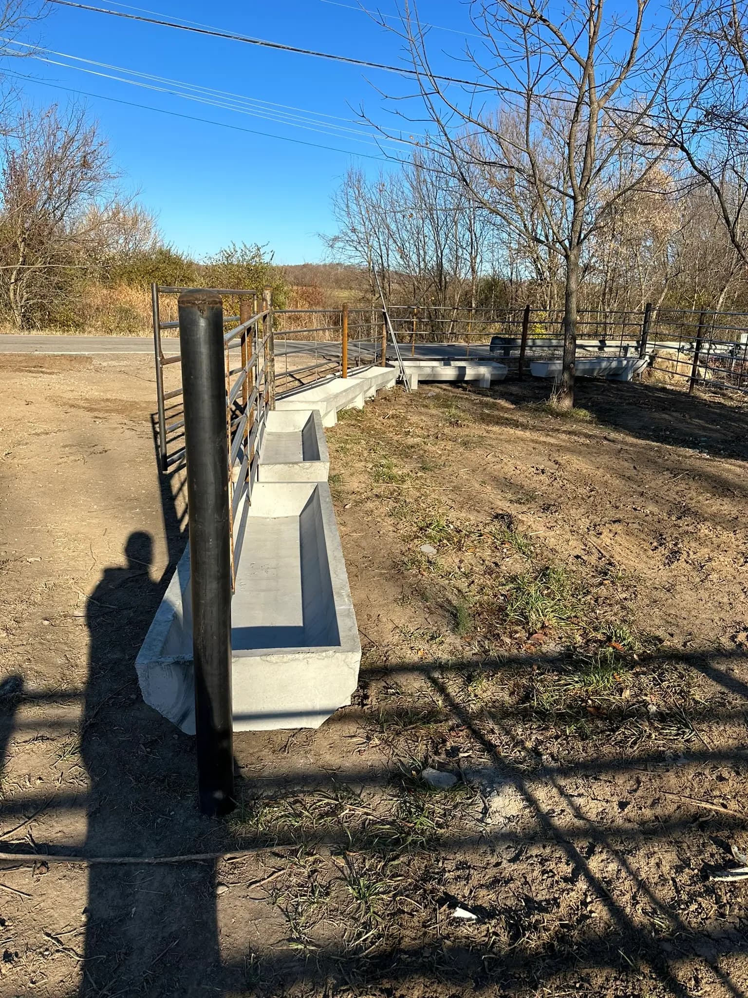 Pipe fence post beside a concrete feed bunk