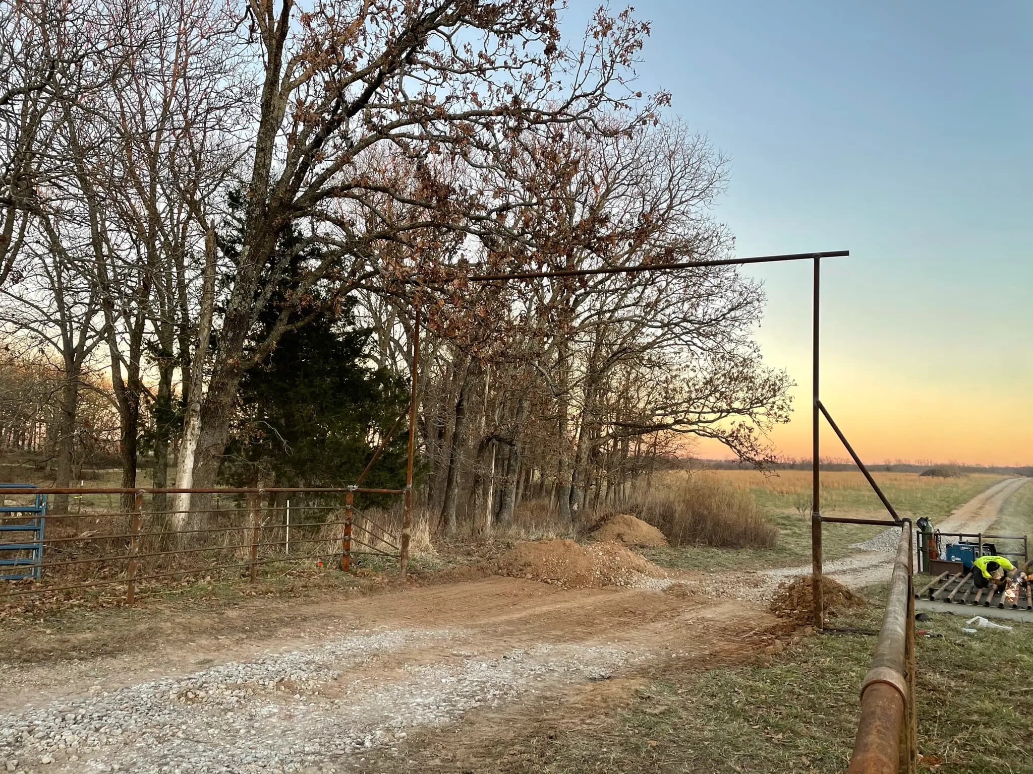 Pipe fence brace and gate post along a farm road