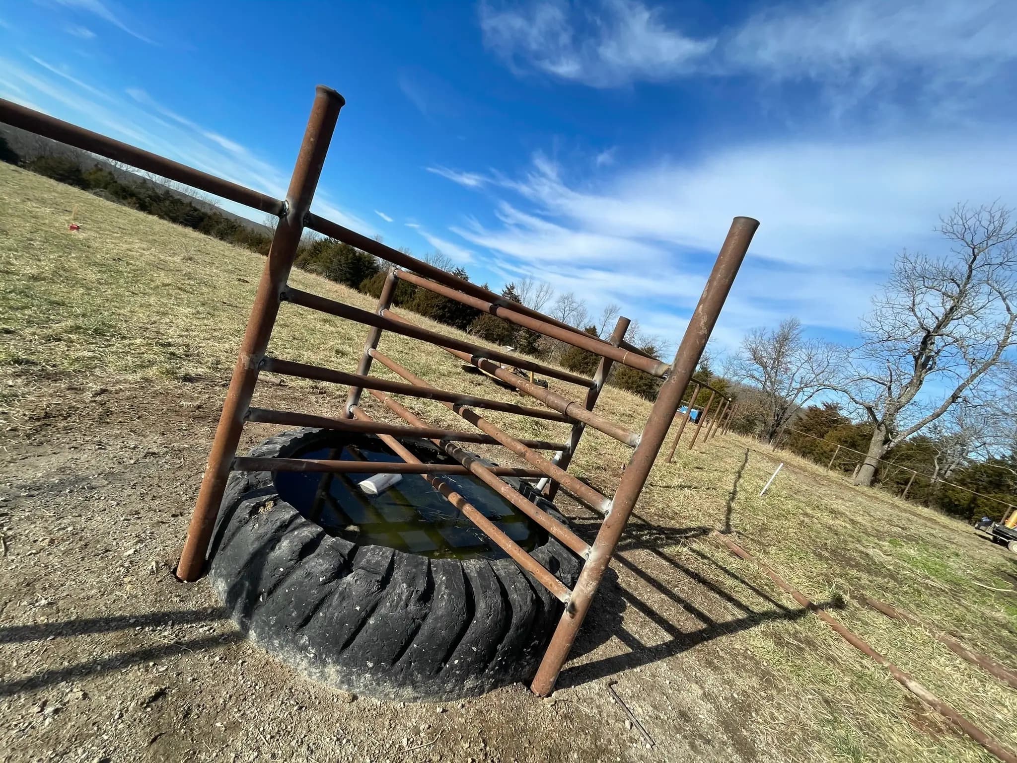 Steel pipe fence panel set on a tire before installation
