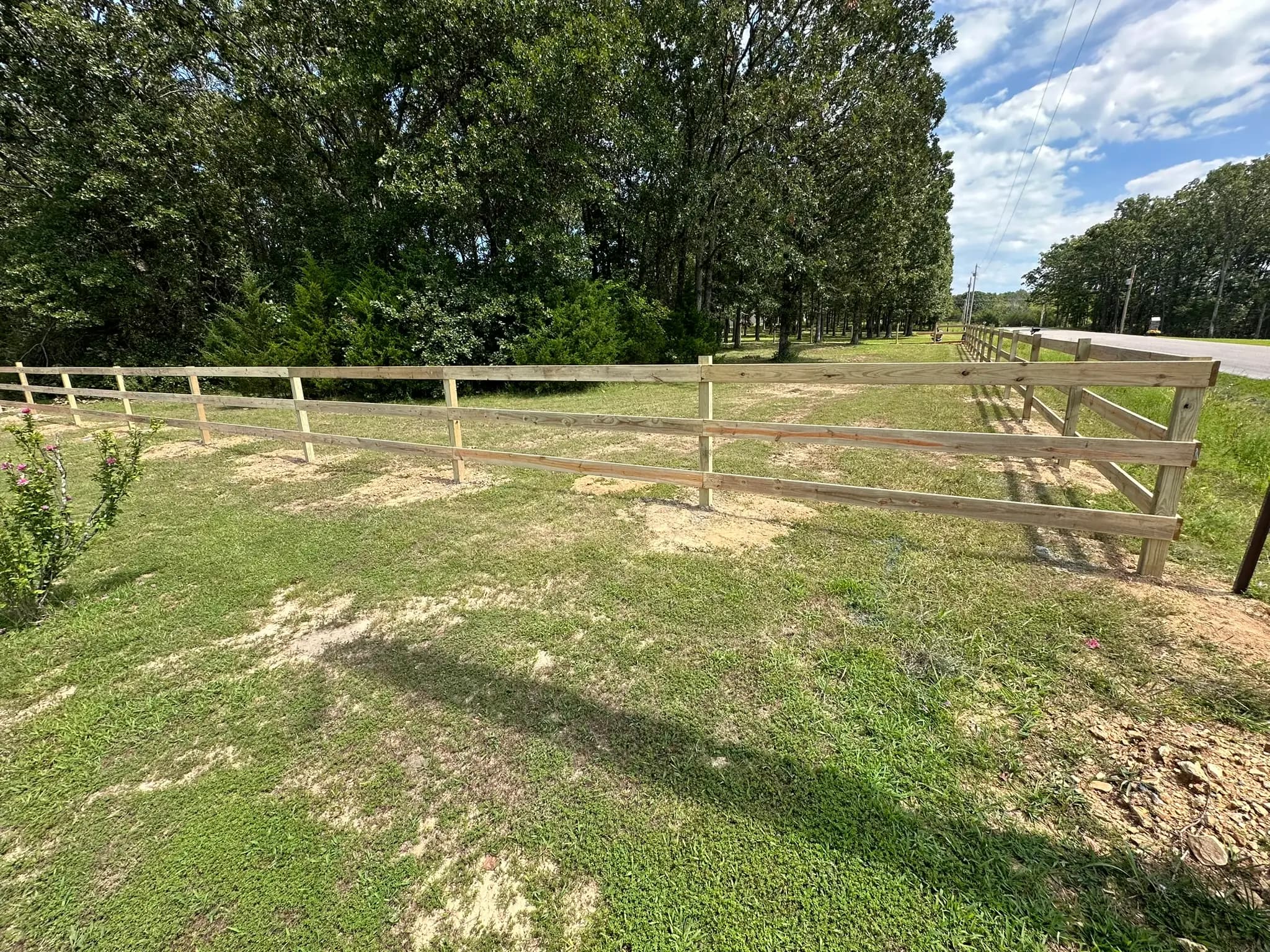Wood rail pasture fence enclosing a grassy paddock