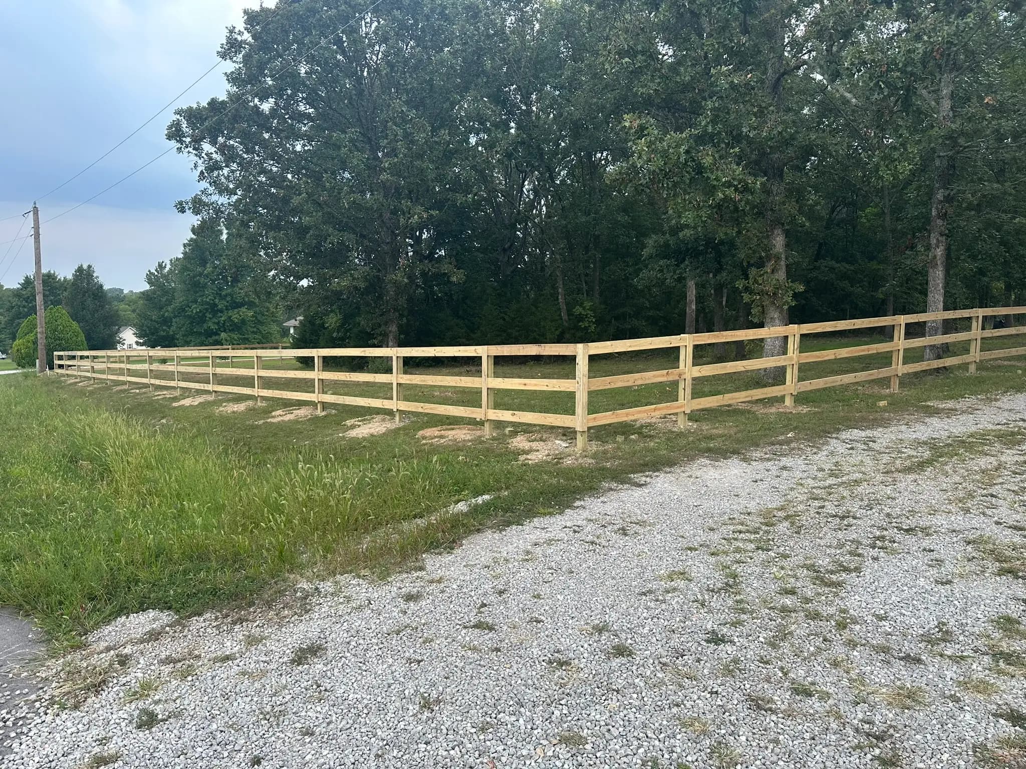 Split rail wood fence beside a gravel drive