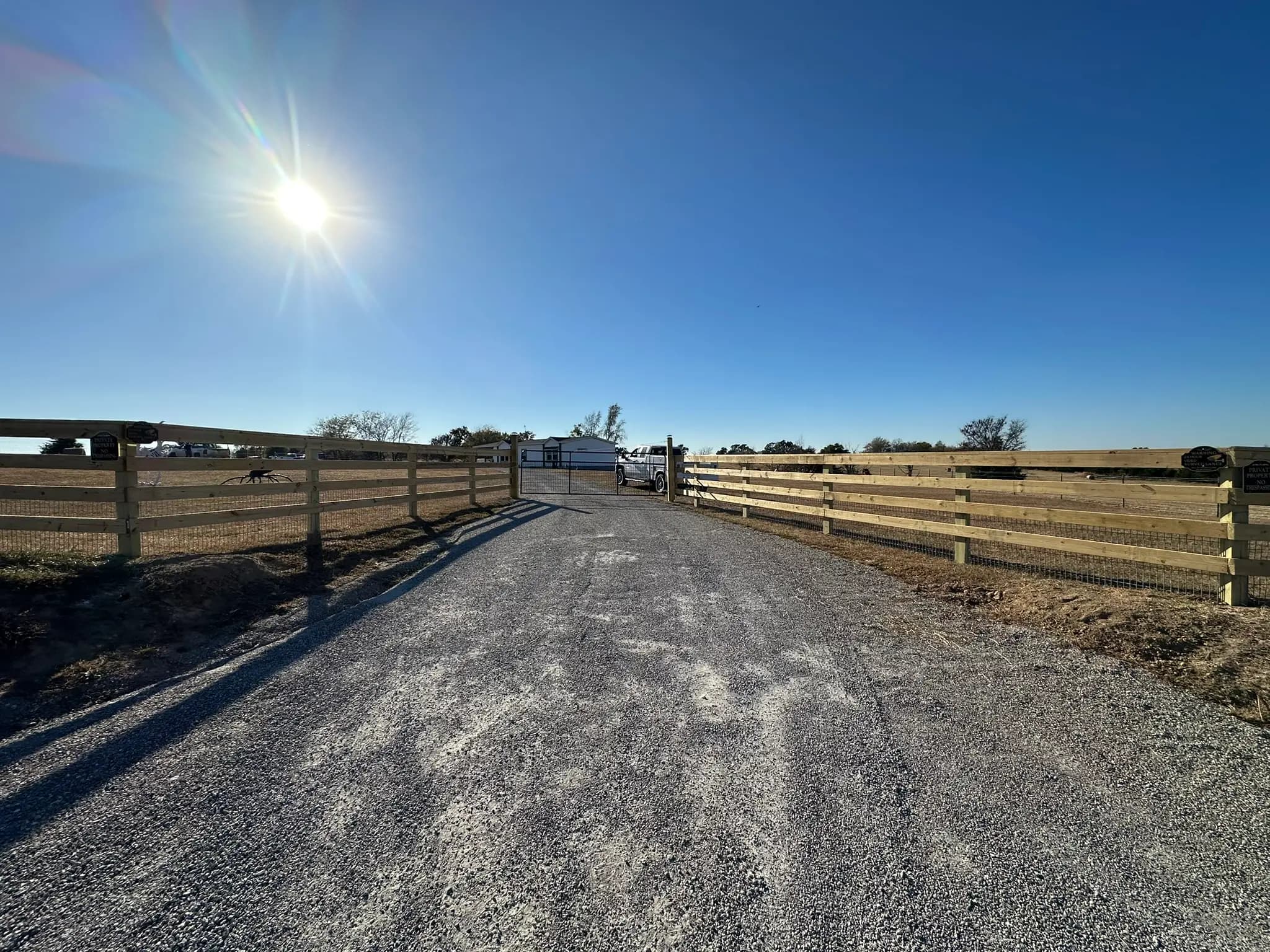 Long wood rail fence bordering a rural drive