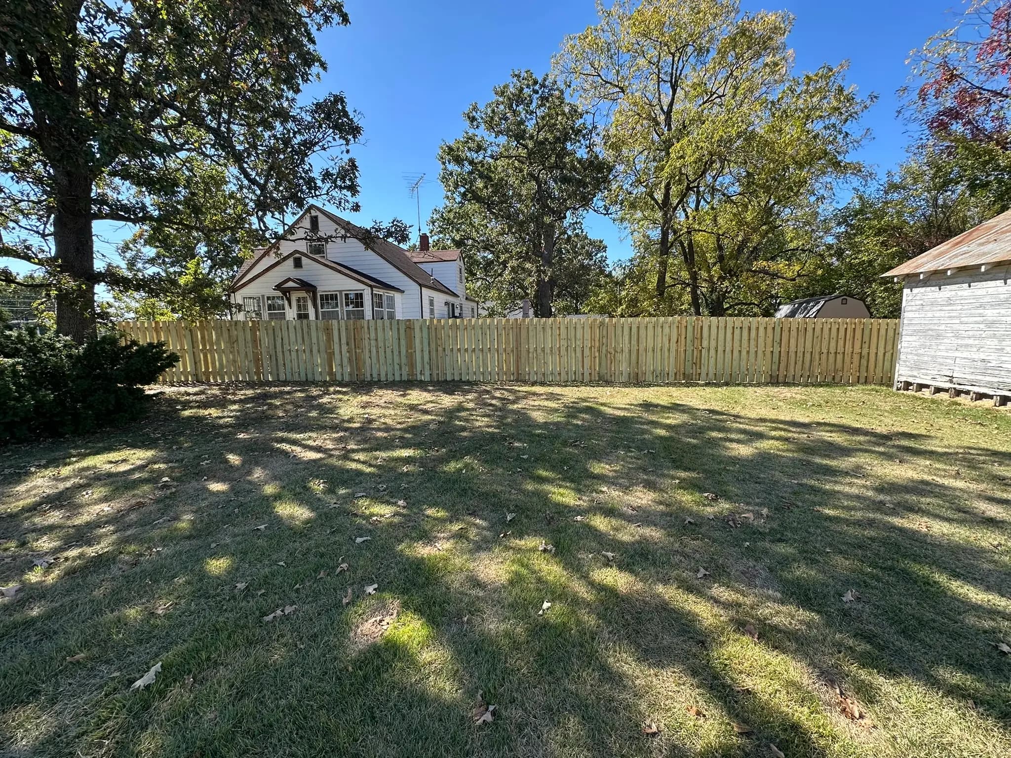 Completed wood privacy fence around a large backyard