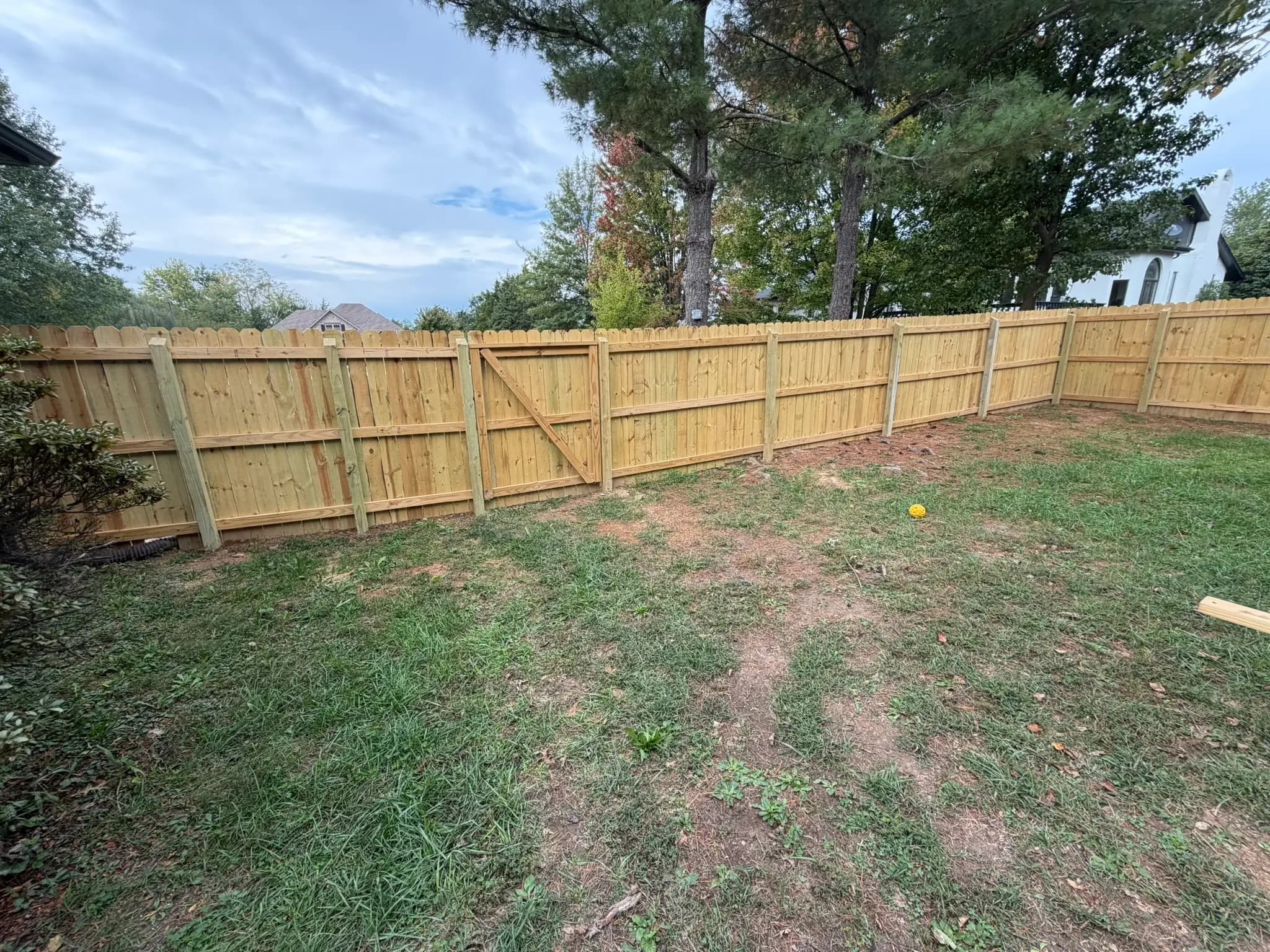 Board-on-board cedar privacy fence along a yard corner