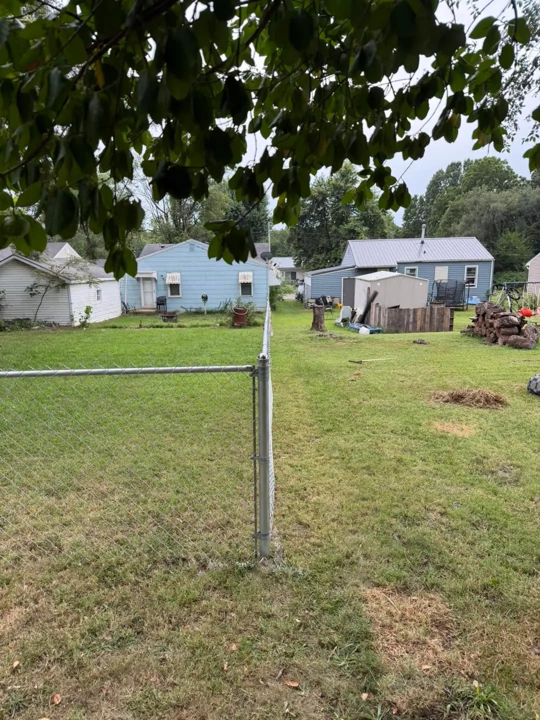 Chain link fence line around a backyard with detached garage
