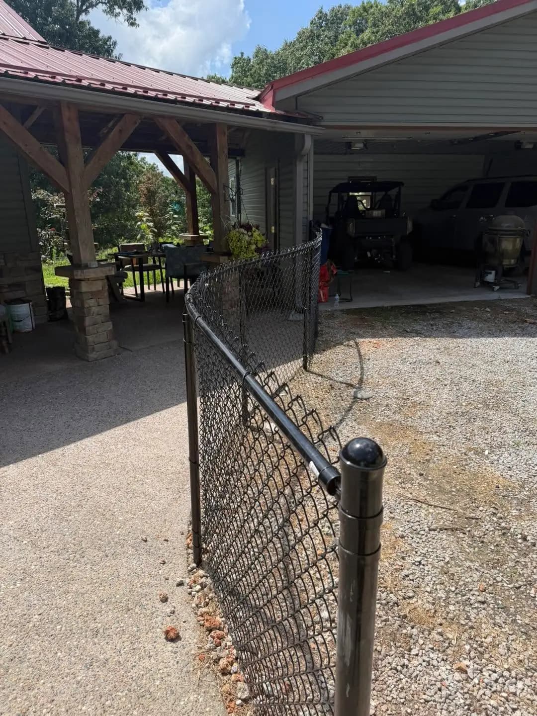 Black chain link gate installed beside a concrete patio