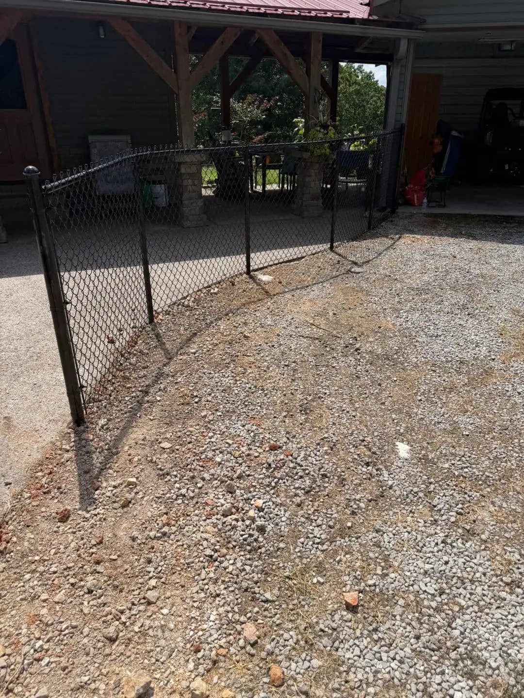 Black chain link fence corner installed along gravel edging