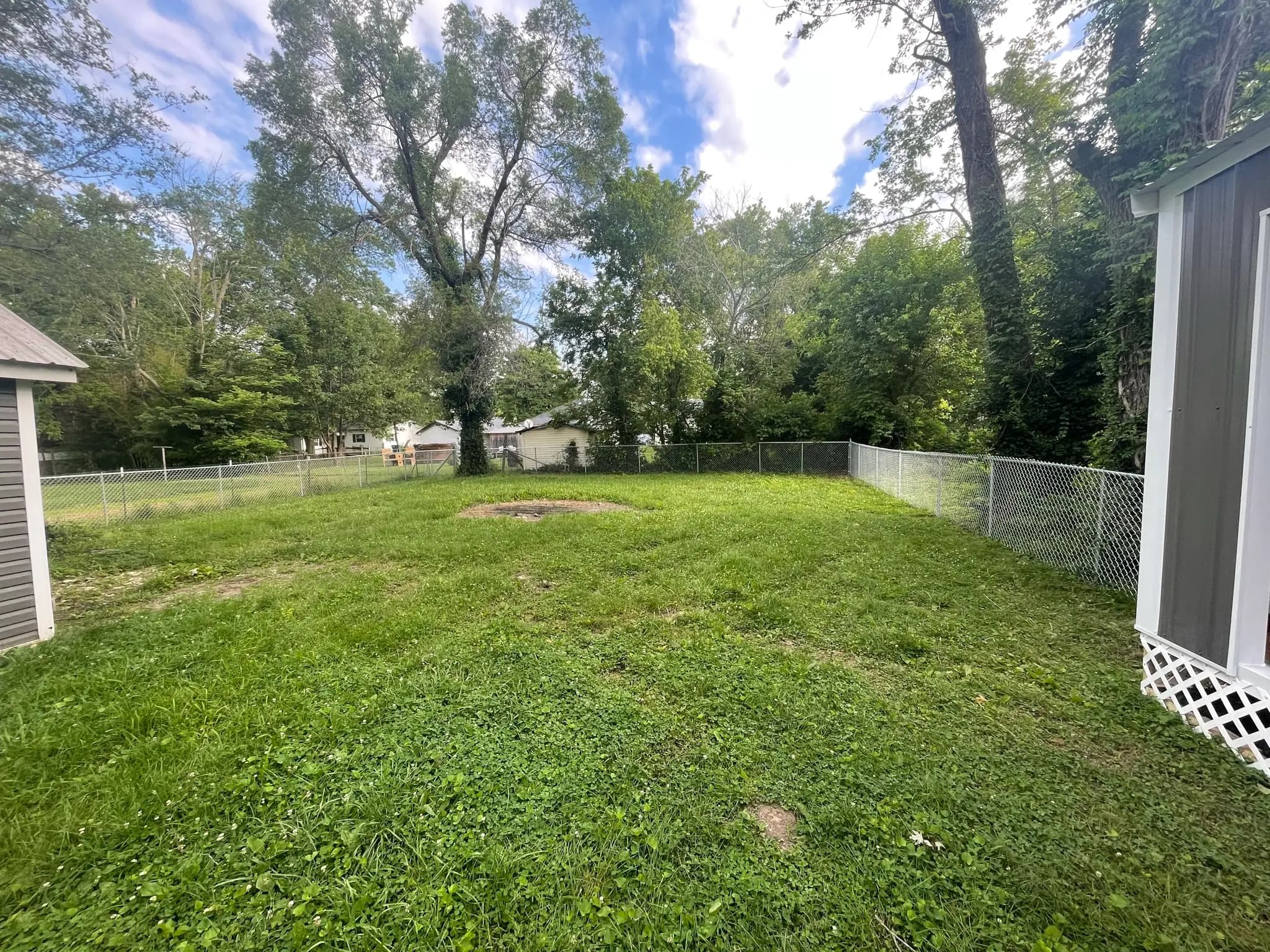 Chain link fence enclosing a backyard between houses
