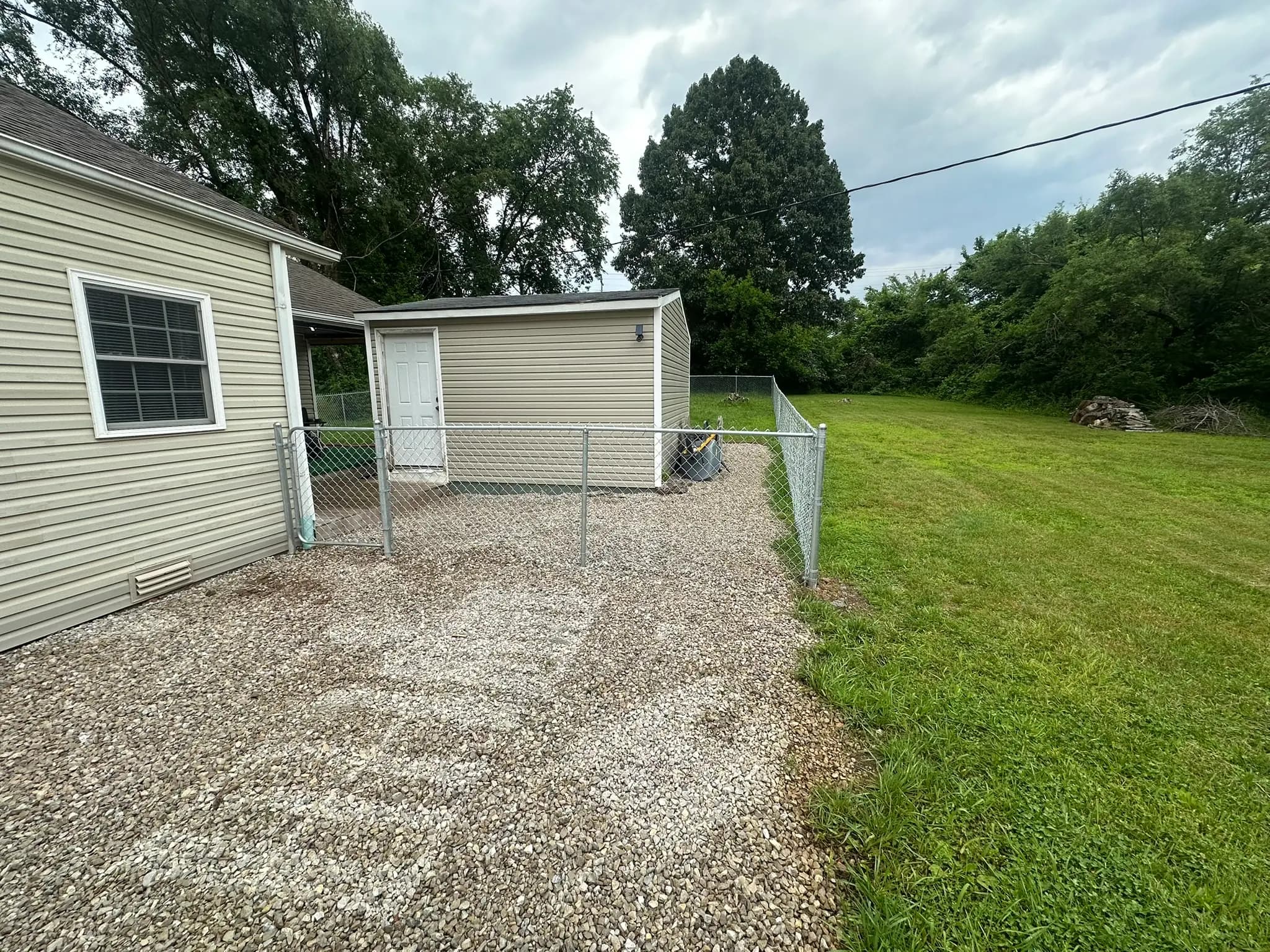 Chain link fence along a side yard and gravel path
