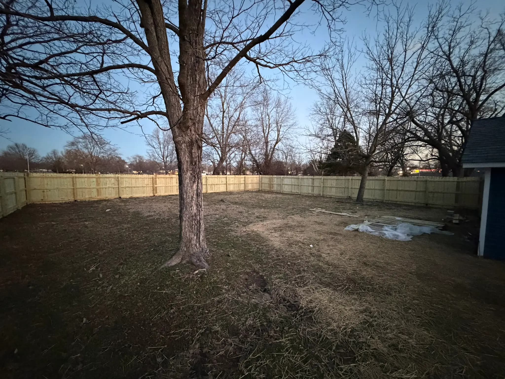Backyard enclosed by a new wood privacy fence