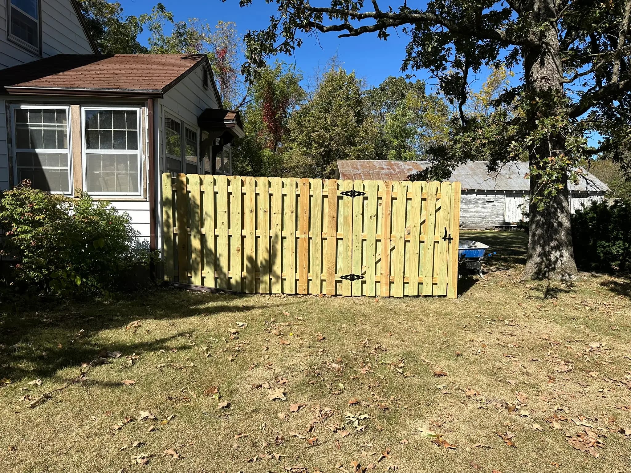 Wood privacy fence gate installed beside a house