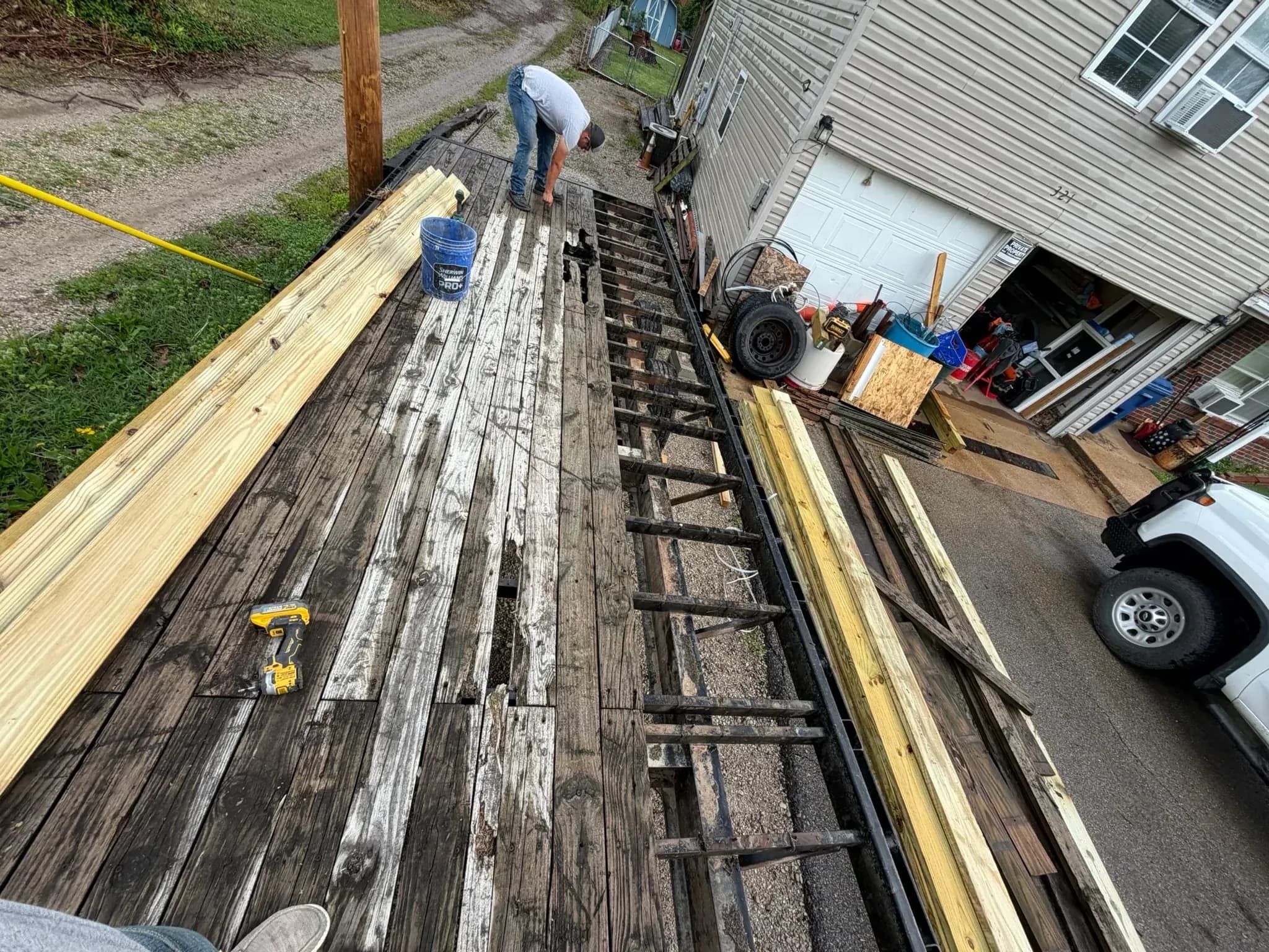Trailer deck rebuild in progress with old boards removed and new lumber staged