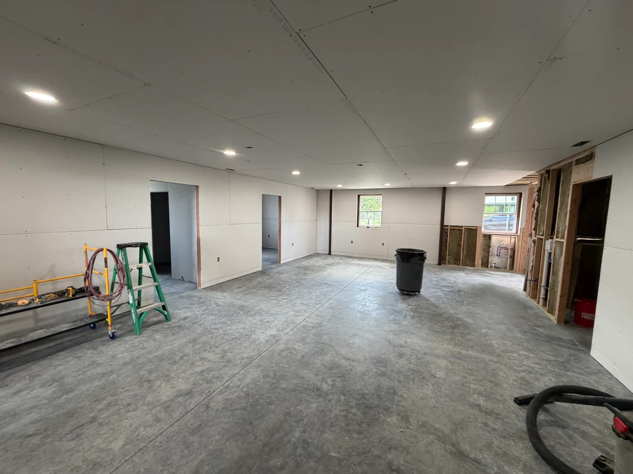 Drywall installation and recessed lighting during an open-room remodel
