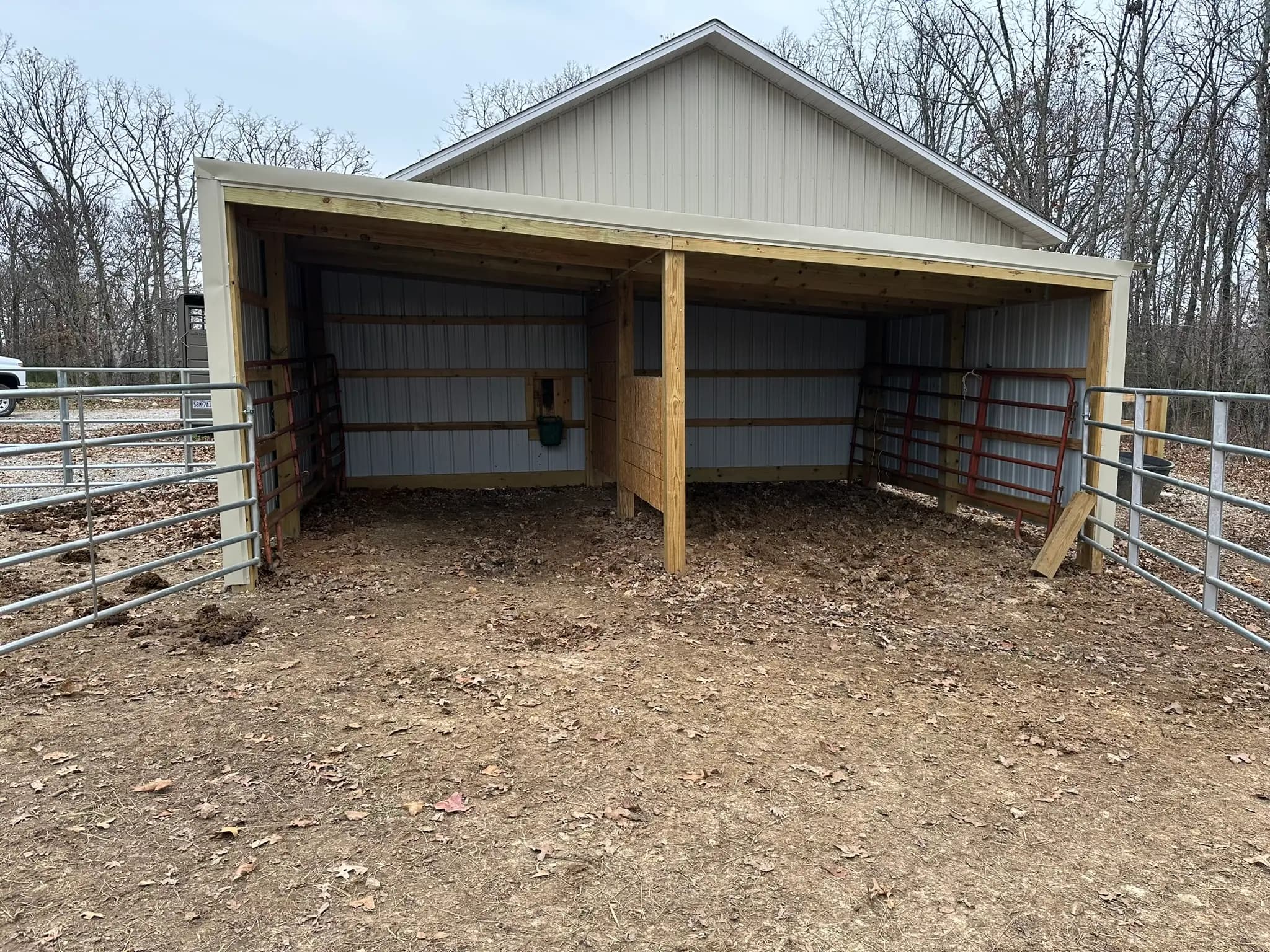 Open-front livestock shed with pipe corral panels