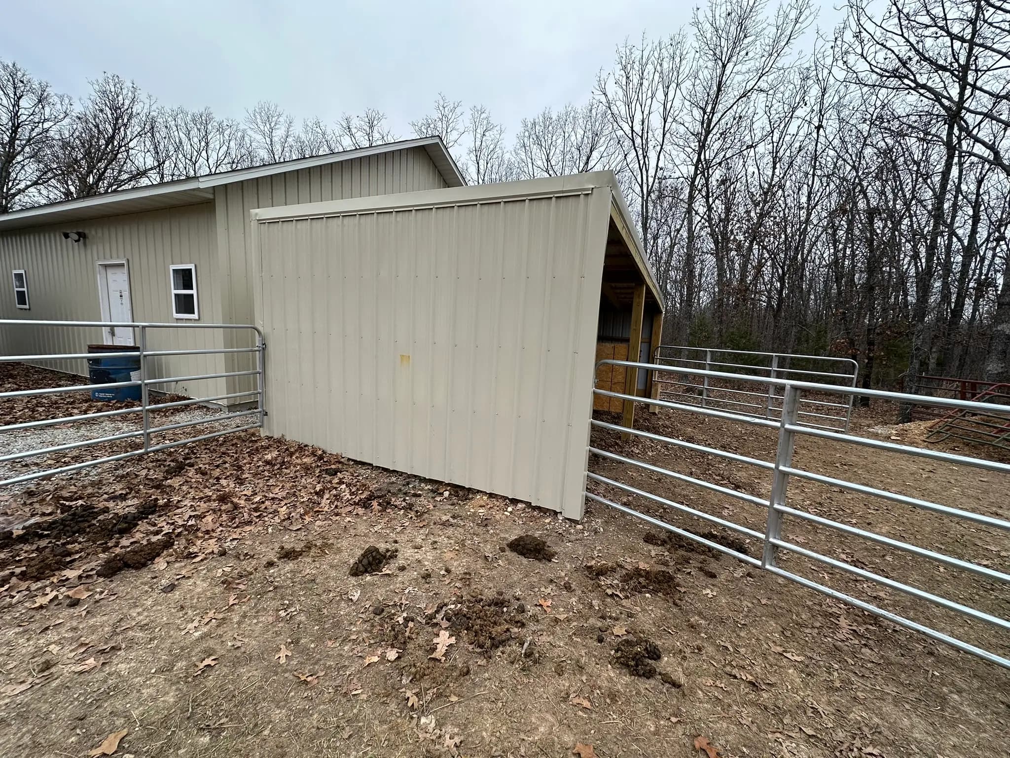 Side view of livestock shed and metal corral fencing