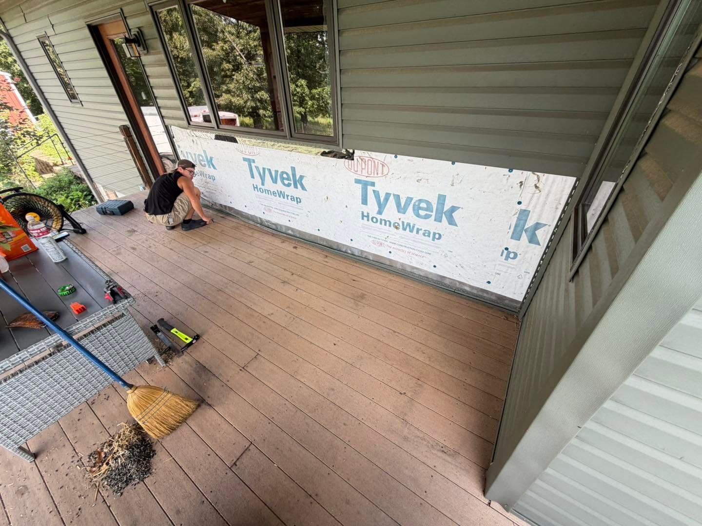 Covered porch wall with housewrap exposed before brick wainscot installation