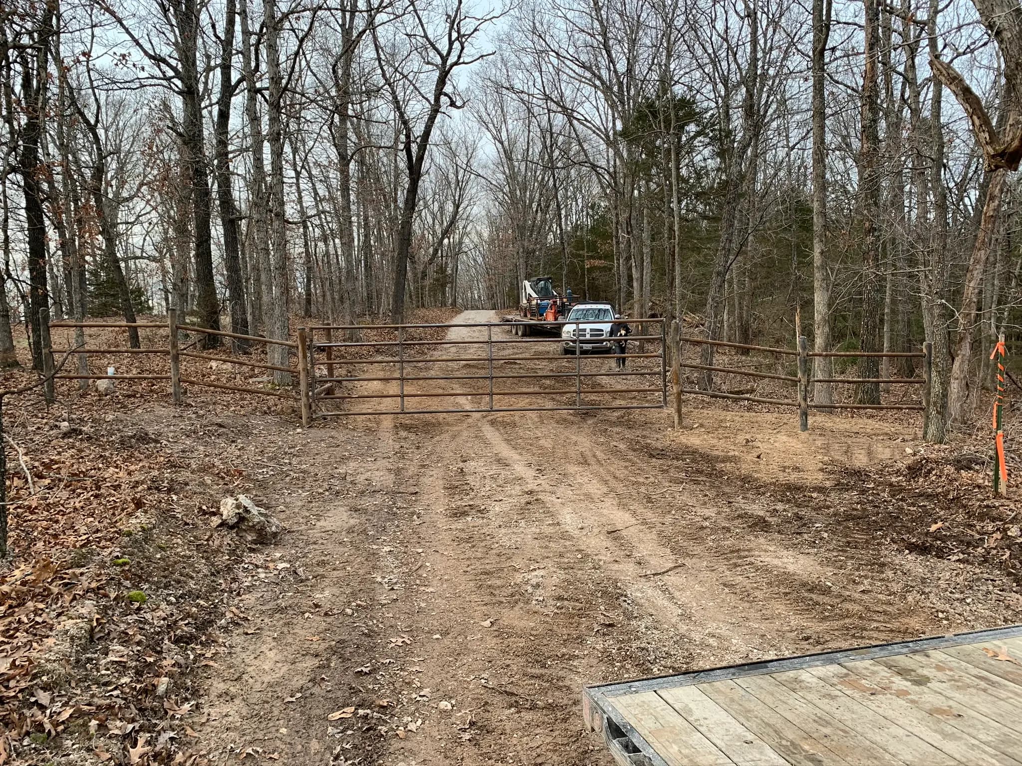 Pipe corral gate installed on a wooded farm lane